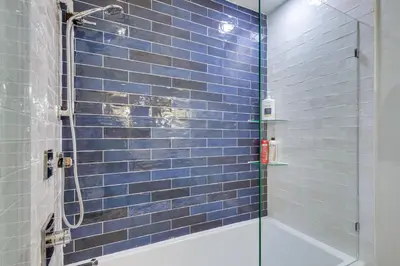 a bathroom with a blue tiled shower with a glass door at Keystone Lake Haven Heated Pool and Ski Shuttle! in Keystone