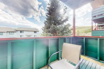 a chair on a balcony with a tree at Cozy Colorado Condo in Dillon