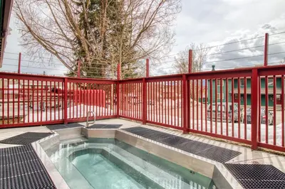 a swimming pool with a red fence and a hot tub at Cozy Colorado Condo in Dillon