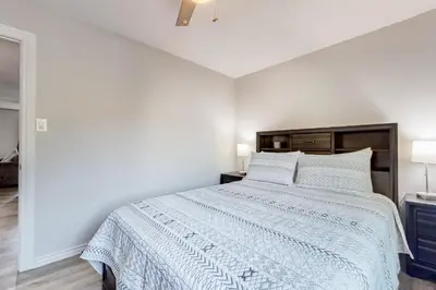 a white bedroom with a bed with a blue comforter at Cozy Colorado Condo in Dillon