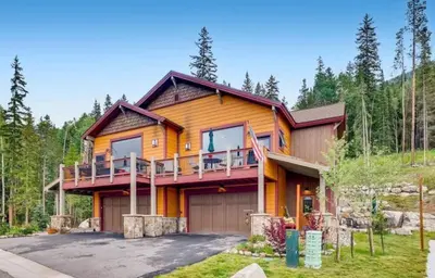 a large wooden house with a porch and a driveway at The Alders Townhomes In East Keystone - Luxury 3 Bedroom Den in Keystone