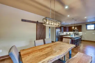 a dining room with a wooden table and a kitchen at The Alders Townhomes In East Keystone - Luxury 3 Bedroom Den in Keystone