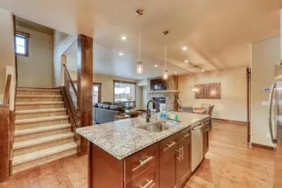 a kitchen and living room with a sink and a staircase at The Alders Townhomes In East Keystone - Luxury 3 Bedroom Den in Keystone