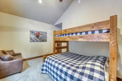a bedroom with a bunk bed and a couch at The Alders Townhomes In East Keystone - Luxury 3 Bedroom Den in Keystone