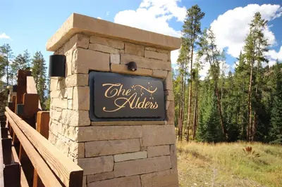 a sign for the alleys on a wooden bridge at The Alders Townhomes In East Keystone - Luxury 3 Bedroom Den in Keystone