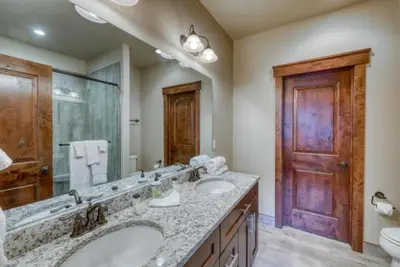 a bathroom with two sinks and a large mirror at The Alders Townhomes In East Keystone - Luxury 3 Bedroom Den in Keystone
