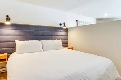 a bedroom with a large white bed with a wooden headboard at 1 Mi to Keystone Resort Mtn-View Family Escape! in Keystone