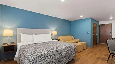 a hotel room with a bed and a chair at WoodSpring Suites Greeley in Greeley