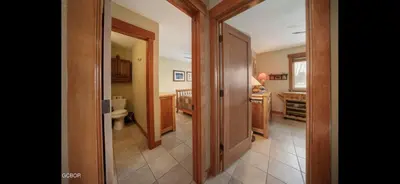 a hallway to a bathroom with a toilet and a sink at Riverside Retreat in Funky Fraser on Train, Bike and Bus Routes in Fraser