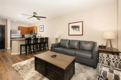 a living room with a couch and a kitchen at Ski-In/Ski-Out Zephyr 1 Bedroom Condo Winter Park in Winter Park