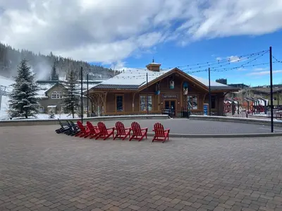 a group of red chairs in front of a building at Ski-In/Ski-Out Zephyr 1 Bedroom Condo Winter Park in Winter Park