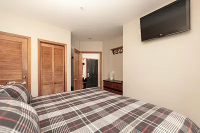 a bedroom with a bed and a television on the wall at Ski-In/Ski-Out Zephyr 1 Bedroom Condo Winter Park in Winter Park