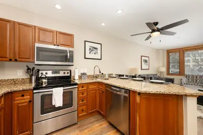a kitchen with stainless steel appliances and a ceiling fan at Ski-In/Ski-Out Zephyr 1 Bedroom Condo Winter Park in Winter Park