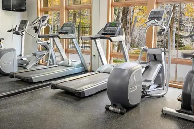 a gym with several treadmills and elliptical machines at Ski-In/Ski-Out Zephyr 1 Bedroom Condo Winter Park in Winter Park