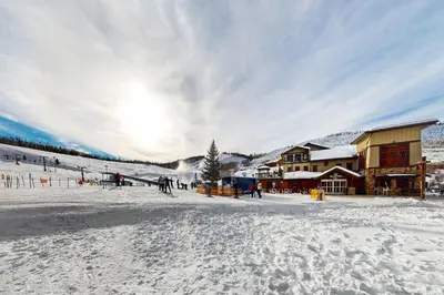 a ski lodge in the snow with people skiing at 310 Base Camp in Granby