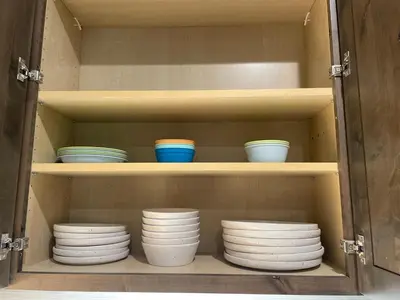 a cabinet filled with plates and bowls on shelves at Winter Park Condo w/Hot Tub & 4 Mi to Skiing in Winter Park