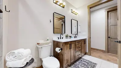 a bathroom with a toilet and a sink and a mirror at Winter Park Condo w/Hot Tub & 4 Mi to Skiing in Winter Park