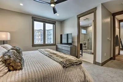 a bedroom with a large bed and a television at Winter Park Condo w/Hot Tub & 4 Mi to Skiing in Winter Park