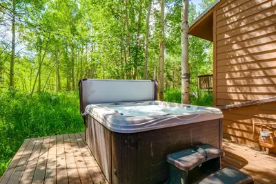 a hot tub sitting on a deck in the woods at Hot Tub Family Gem 3 Mi to Frisco Nordic Center in Frisco