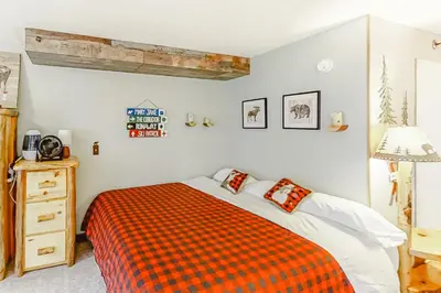 a bedroom with a bed with an orange blanket at Iron Horse Resort D3084 in Winter Park