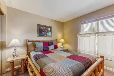 a bedroom with a bed and a window at On the Rapids - A Unit in Grand Lake