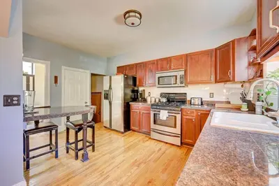 a kitchen with wooden cabinets and stainless steel appliances at Victorian Manor 1 mile from Downtown Denver! in Denver