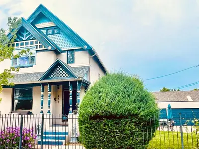 a blue and white house with a fence at Victorian Manor 1 mile from Downtown Denver! in Denver