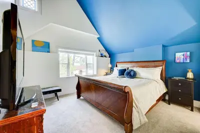 a bedroom with blue walls and a bed and a tv at Victorian Manor 1 mile from Downtown Denver! in Denver