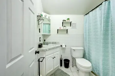 a white bathroom with a toilet and a sink at Victorian Manor 1 mile from Downtown Denver! in Denver