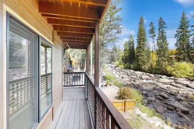 a balcony with a view of a river at On the Rapids - B Unit in Grand Lake