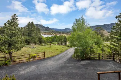a road in a field with a fence at Alpine Suite - Minutes to RMNP, Hot Tub! in Estes Park