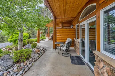 a porch of a house with a table and chairs at Alpine Suite - Minutes to RMNP, Hot Tub! in Estes Park