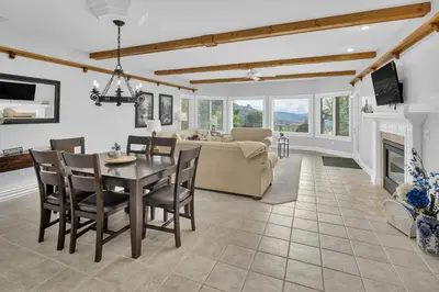 a dining room and living room with a table and chairs at Alpine Suite - Minutes to RMNP, Hot Tub! in Estes Park
