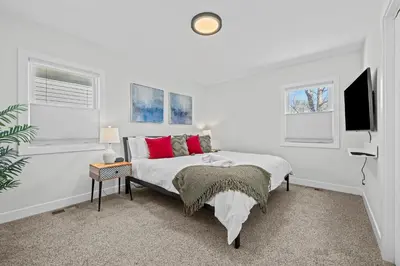 a white bedroom with a bed and a flat screen tv at 6224 S Datura St in Littleton