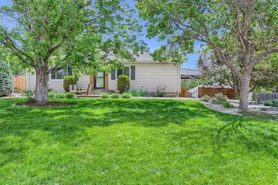 a house with a yard with green grass and trees at 6224 S Datura St in Littleton