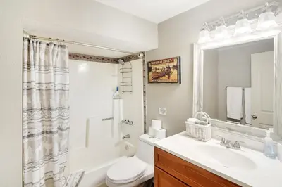 a bathroom with a sink and a toilet and a mirror at The Tree House in Evergreen