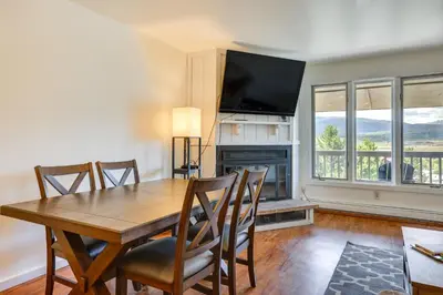 a dining room with a table and a fireplace at Fraser Condo Rental with Balcony, Mountain Views! in Fraser