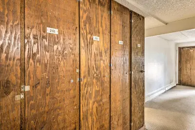 a row of wooden lockers in an empty room at Fraser Condo Rental with Balcony, Mountain Views! in Fraser