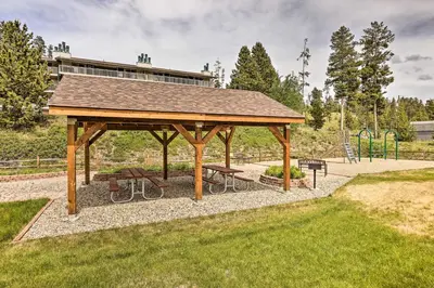 a wooden gazebo in a park with benches at Fraser Condo Rental with Balcony, Mountain Views! in Fraser