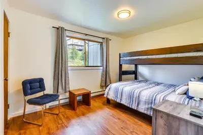 a bedroom with a bed and a chair and a window at Fraser Condo Rental with Balcony, Mountain Views! in Fraser