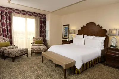 a hotel room with a large bed and a chair at Woolley's Classic Suites in Aurora