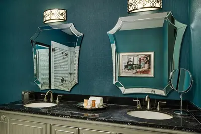 a bathroom with two sinks and two mirrors at Woolley's Classic Suites in Aurora