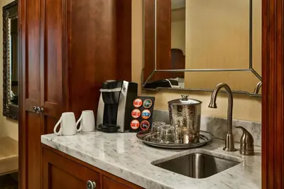 a kitchen counter with a sink and a coffee maker at Woolley's Classic Suites in Aurora