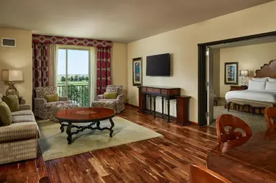 a hotel room with a bed and a living room at Woolley's Classic Suites in Aurora