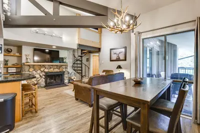 a dining room and living room with a table and a fireplace at Keystone Condo on Shuttle Line Less Than 1 Mi to Resort! in Dillon