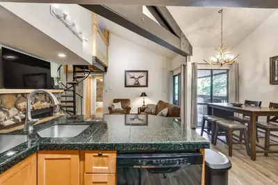 a kitchen with a sink and a living room at Keystone Condo on Shuttle Line Less Than 1 Mi to Resort! in Dillon