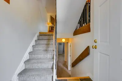 a staircase in a home with white walls and wooden floors at Family-Friendly Fraser Condo with Heated Pool Access in Fraser