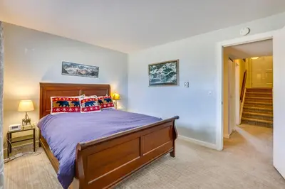 a bedroom with a large bed and a staircase at Family-Friendly Fraser Condo with Heated Pool Access in Fraser