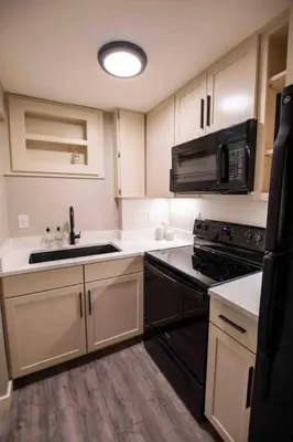 a kitchen with white cabinets and a sink and a microwave at Modern Studio Basement with Private Entrance in Centennial