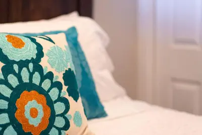 a pillow sitting on top of a bed at Guest Suite Downtown Winter Park GREAT LOCATION in Winter Park